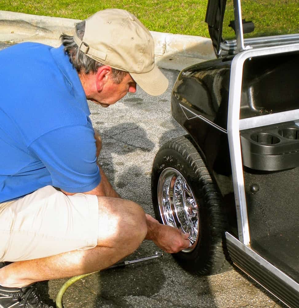 bill checking tire pressure on a golf cart tire