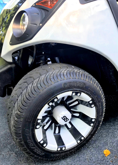 white and black golf cart wheel on a white Yamaha golf cart