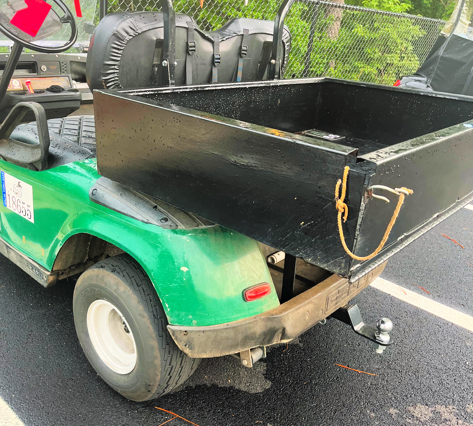 black metal golf cart cargo box behind 2 seater golf cart